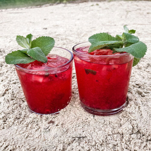 Two Blackberry Mojitos in the sand on the beach