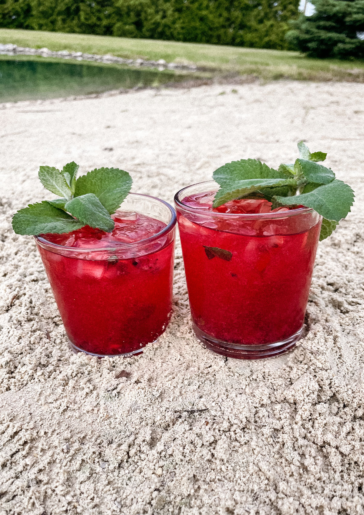 Two Blackberry Mojitos in the sand on the beach