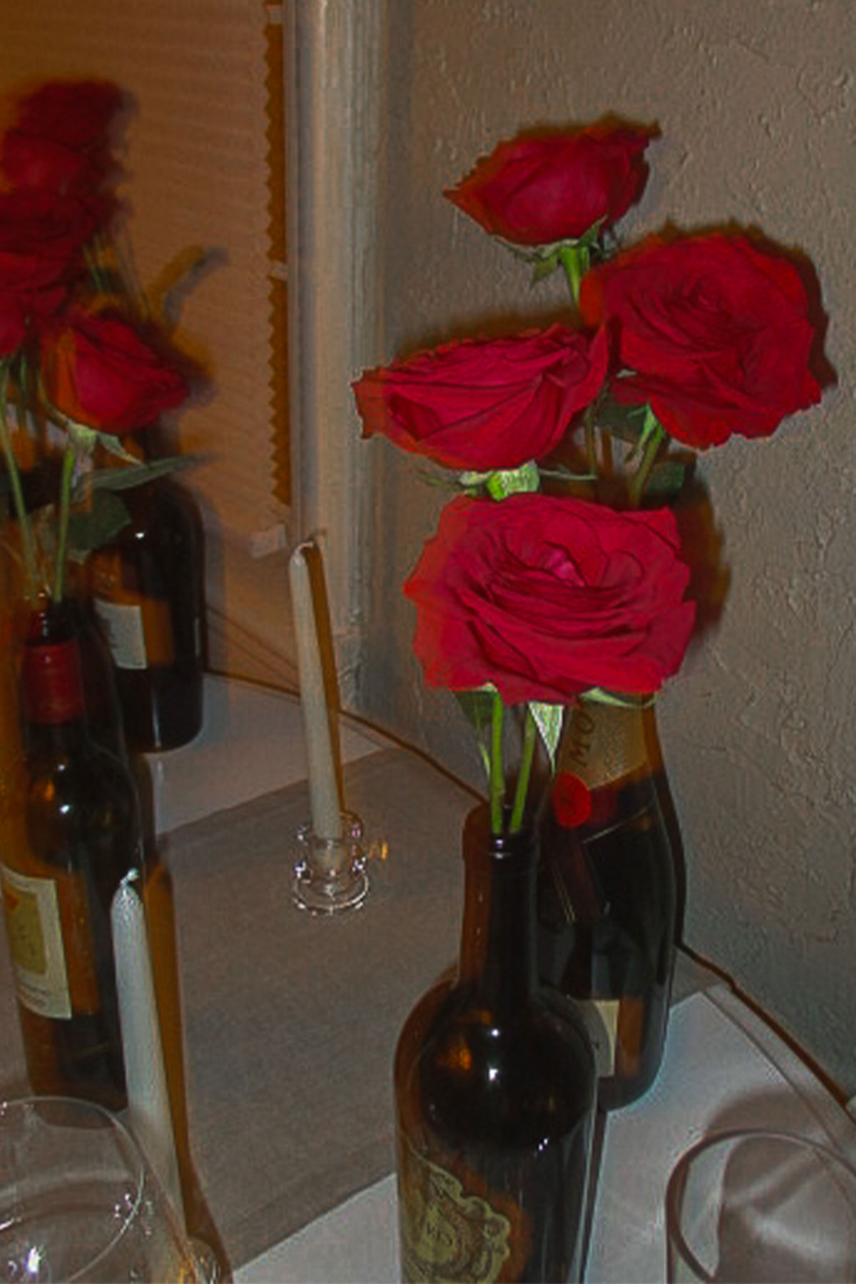 Red roses in empy wine bottles for Valentine's Day decor