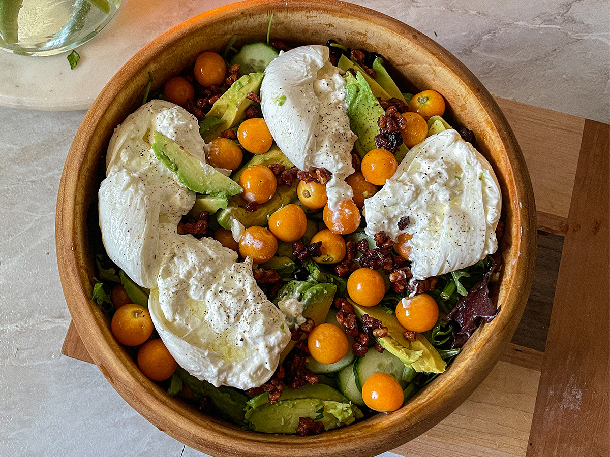 Gooseberry Burrata salad served in a decorative wooden bowl