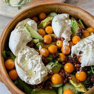 Gooseberry Burrata salad served in a decorative wooden bowl