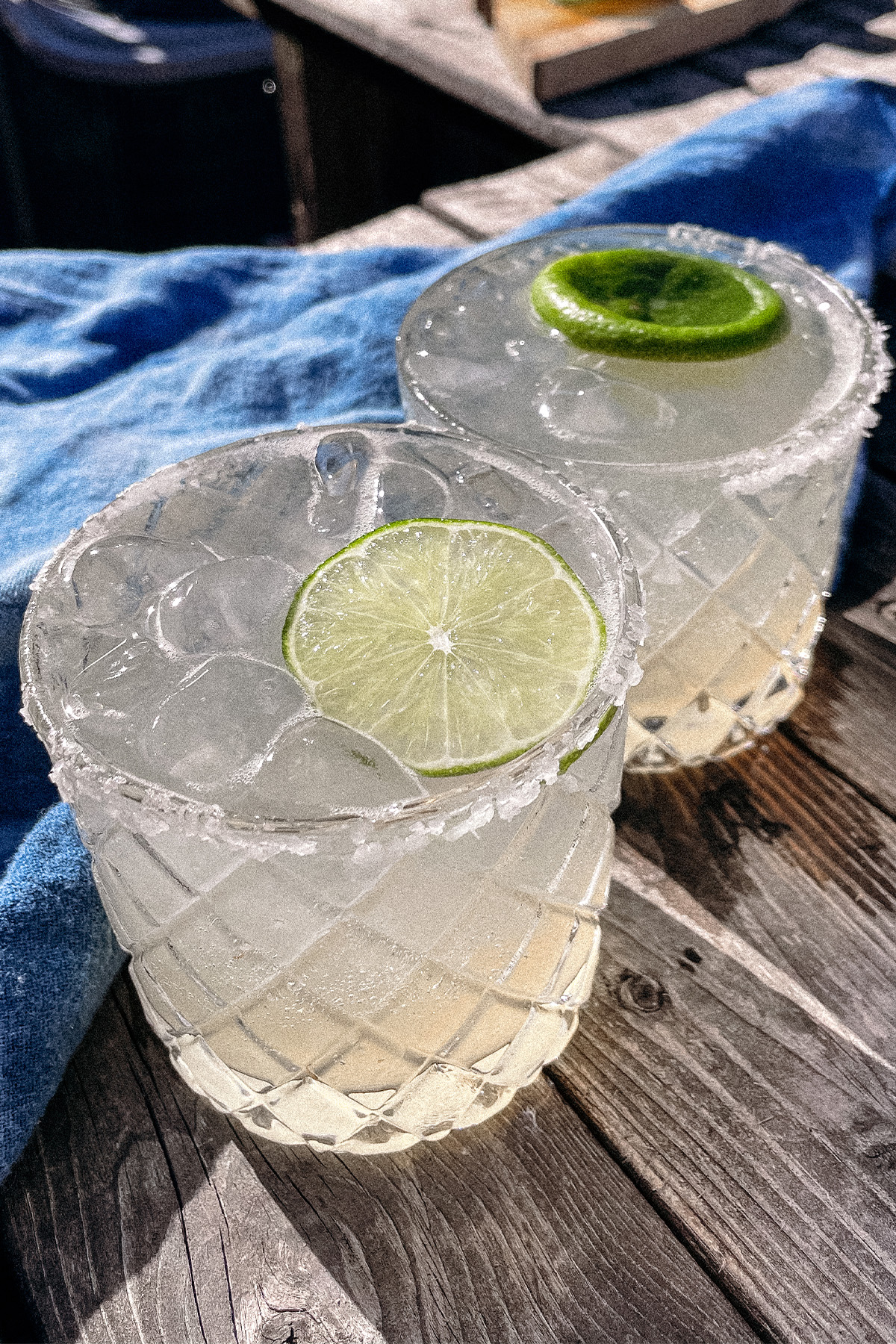 Skinny Margarita cocktails in salt-rimmed glasses topped with a wheel of lime