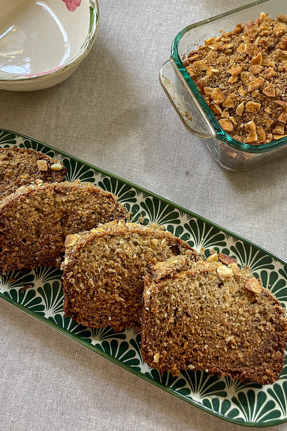 Slices of homemade Brown Sugar-Crusted Banana Bread laid on a serving plate.