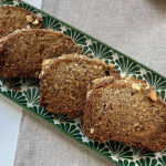 Fresh slices of homemade Brown Sugar-Crusted Banana Bread laid on a serving plate.