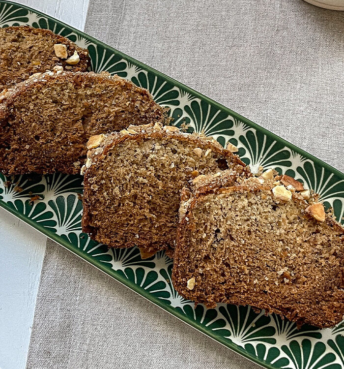 Fresh slices of homemade Brown Sugar-Crusted Banana Bread laid on a serving plate.