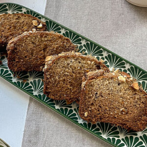 Fresh slices of homemade Brown Sugar-Crusted Banana Bread laid on a serving plate.