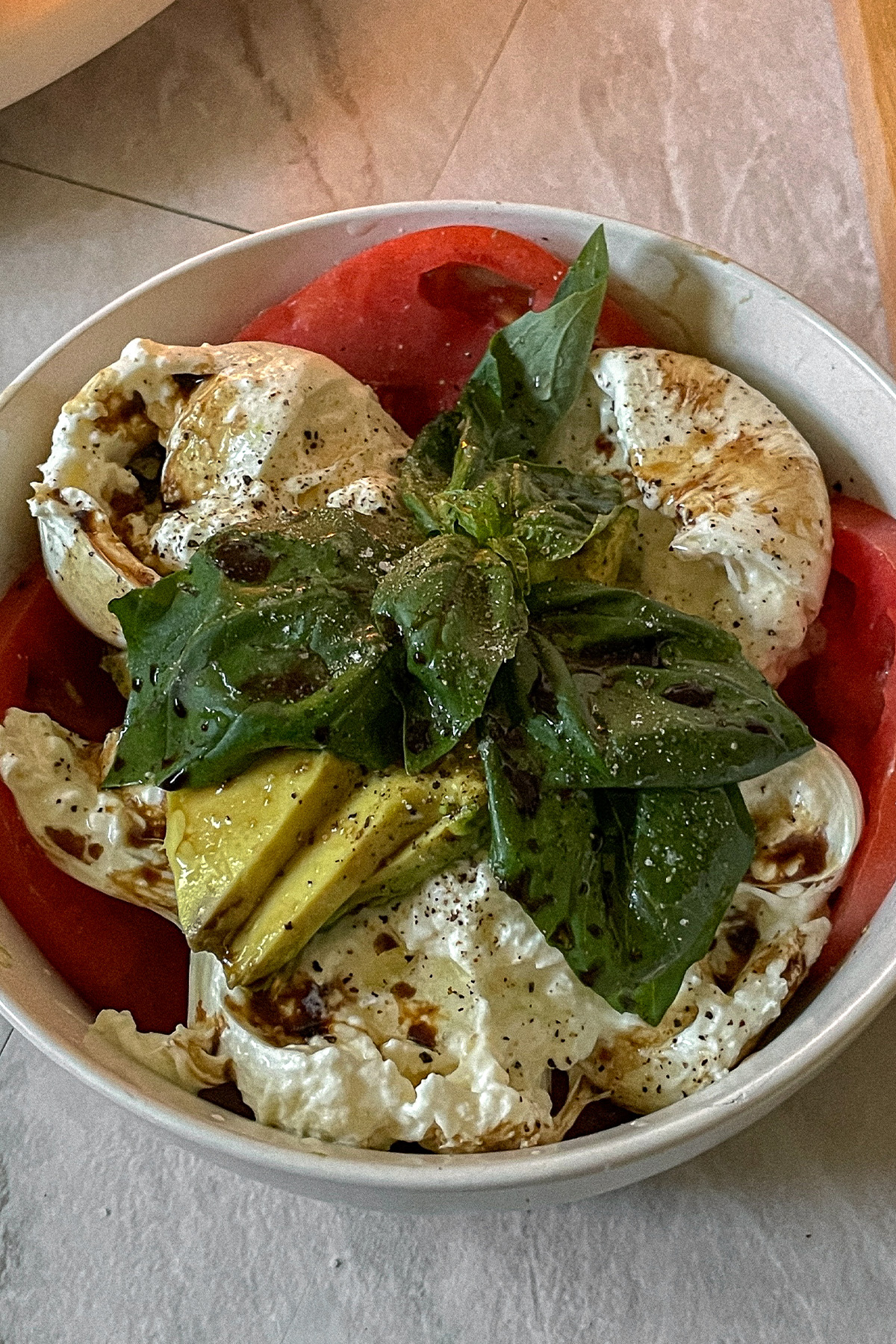 Beautiful Burrata Caprese Salad layered in a bowl