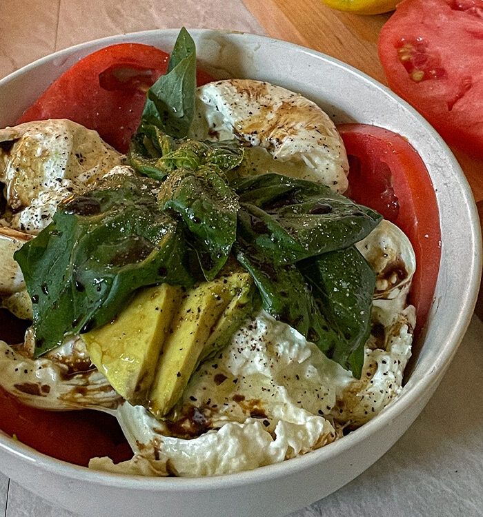 Beautiful Burrata Caprese Salad layered in a bowl