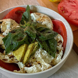 Beautiful Burrata Caprese Salad layered in a bowl