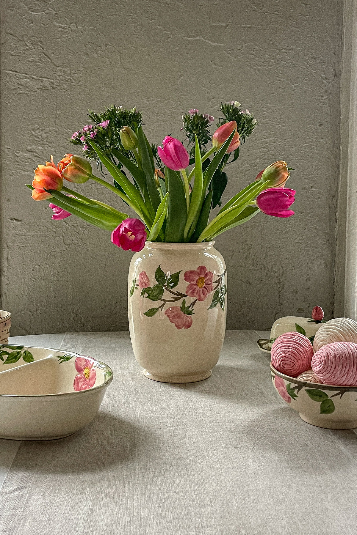 Easter table with a colorful bouquet of spring flowers in an antique vase and decorative Easter eggs