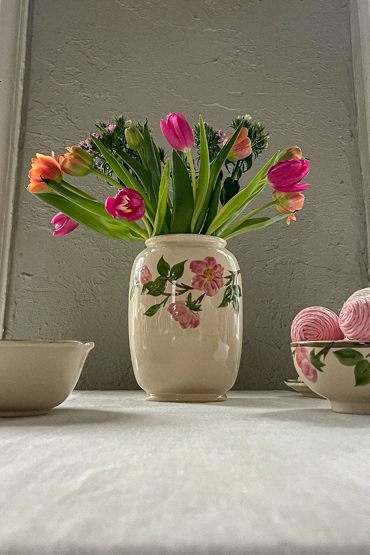 Easter table with a colorful bouquet of spring flowers in an antique vase and decorative Easter eggs