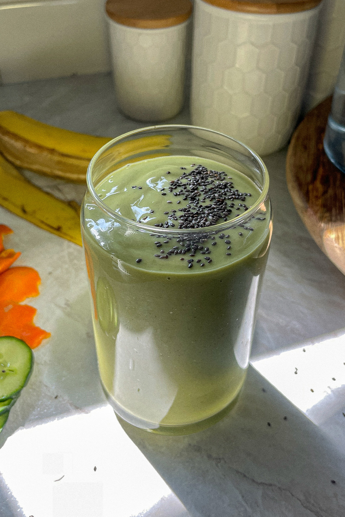 Refreshing tropical green smoothie in a glass topped with chia seeds