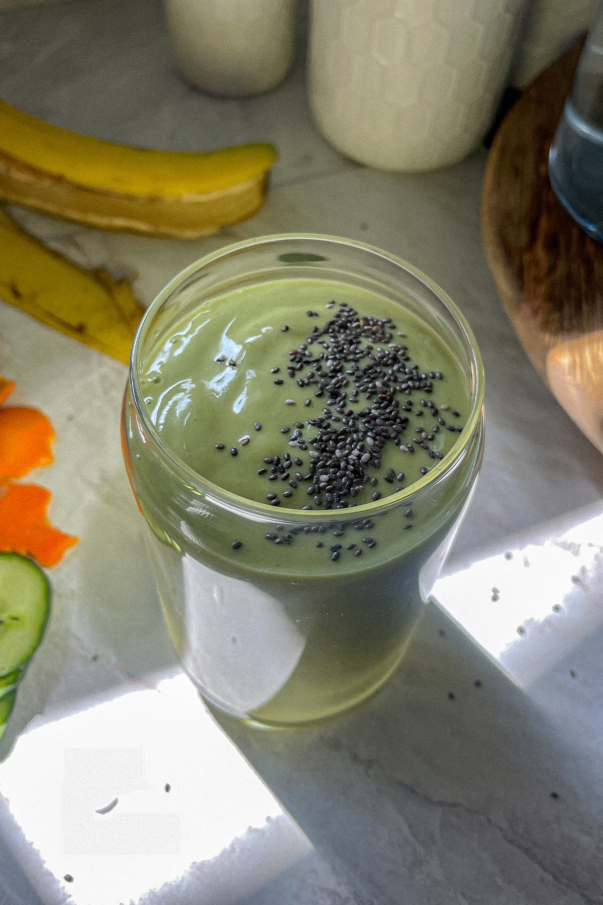 Tropical green smoothie in a glass topped with chia seeds