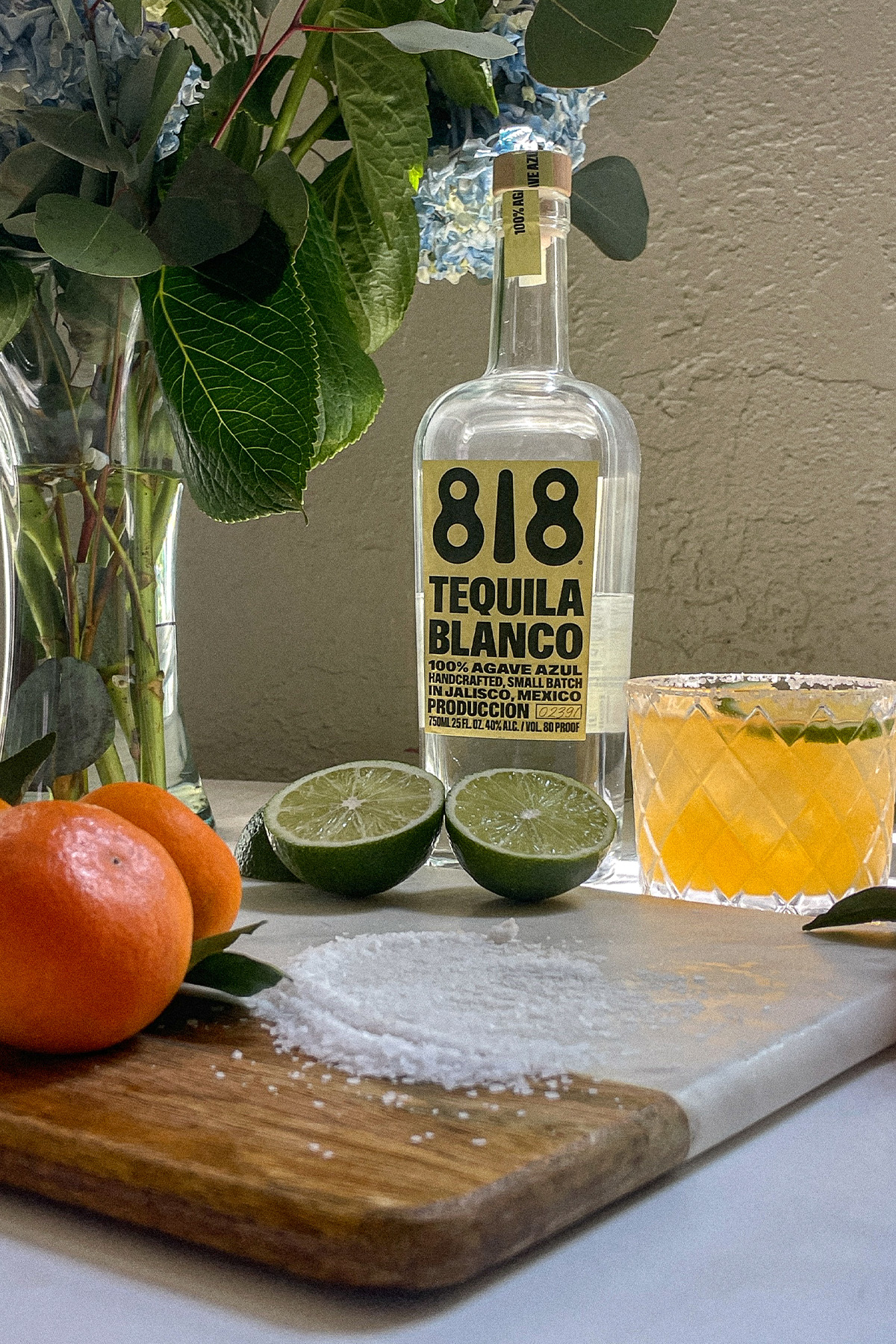 Ingredients for a mandarin orange margarita: 818 tequila, limes, mandarin oranges and margarita salt