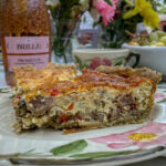 Slice of Italian Sausage Red Pepper Quiche on a pink floral plate