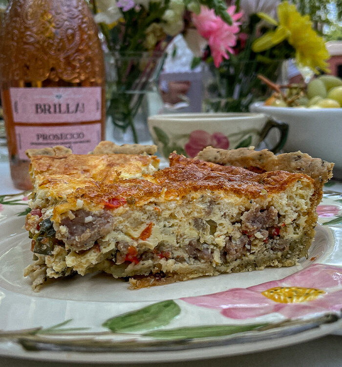 Slice of Italian Sausage Red Pepper Quiche on a pink floral plate