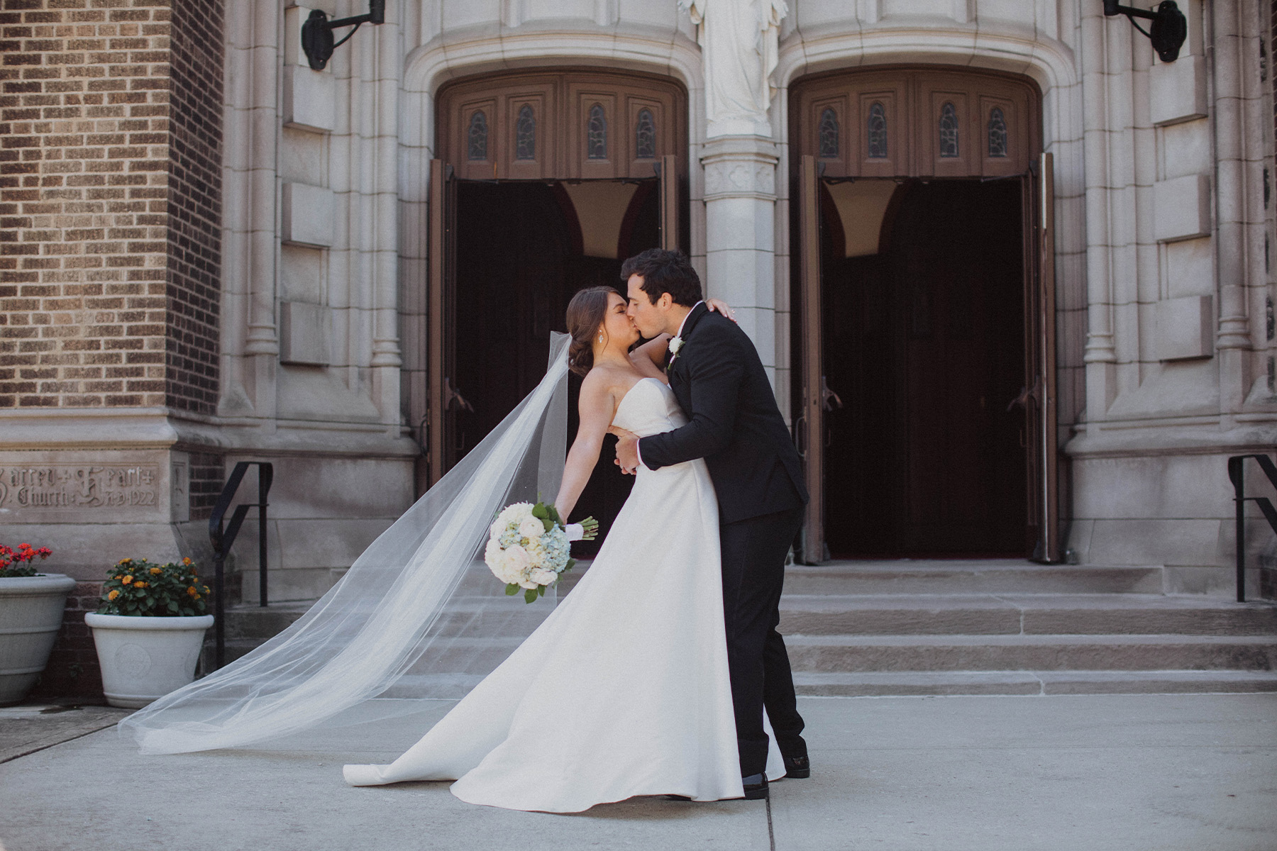 Bride and groom sharing a kiss outside the church