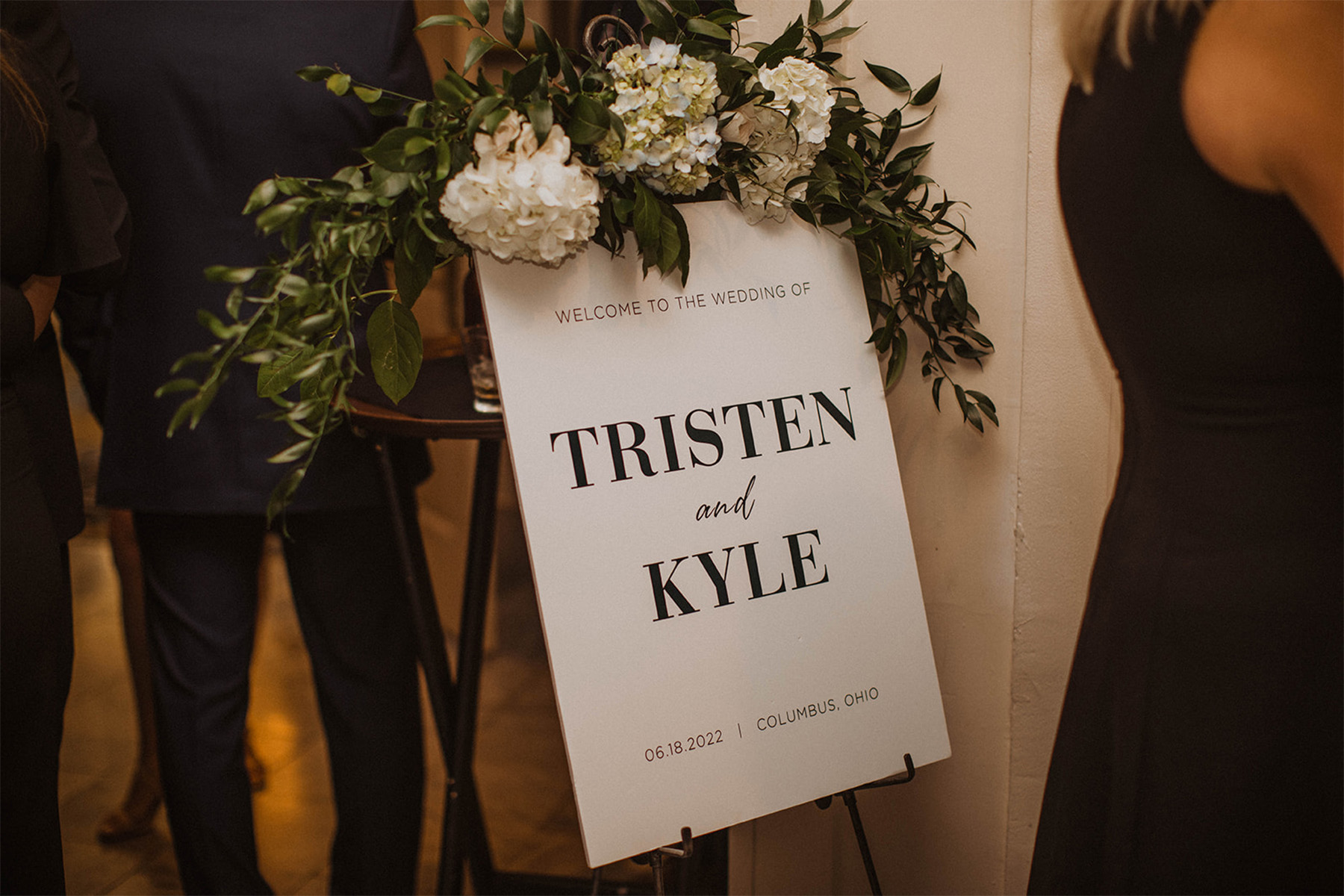 Chic black and white wedding sign topped with flowers