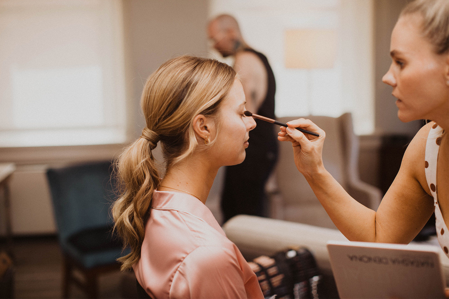 Makeup artist working on bridesmaid