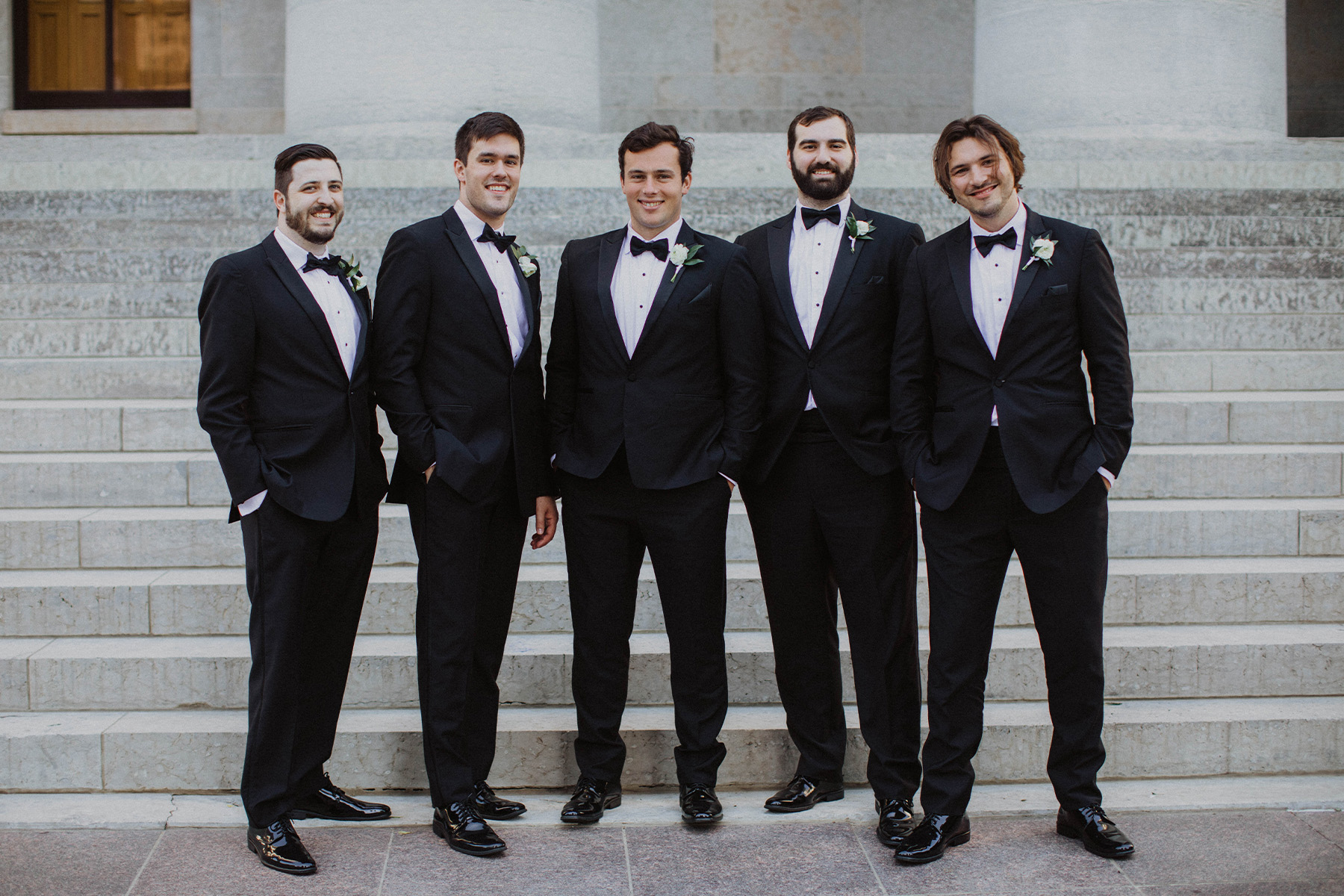 Groomsmen posing in black tuxedos in downtown Columbus, Ohio