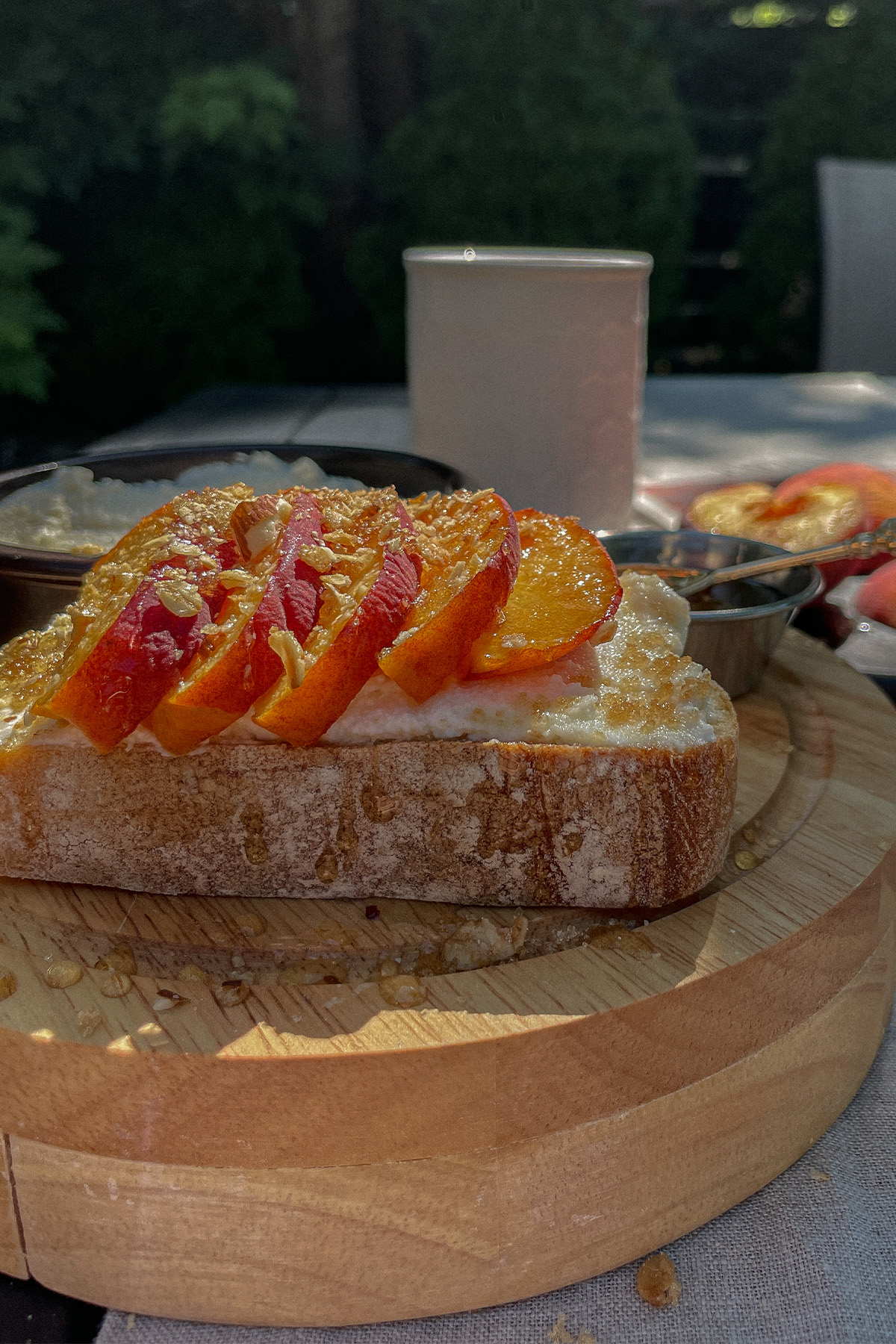 Beautiful slice of Peach Ricotta Toast on a wooden tray