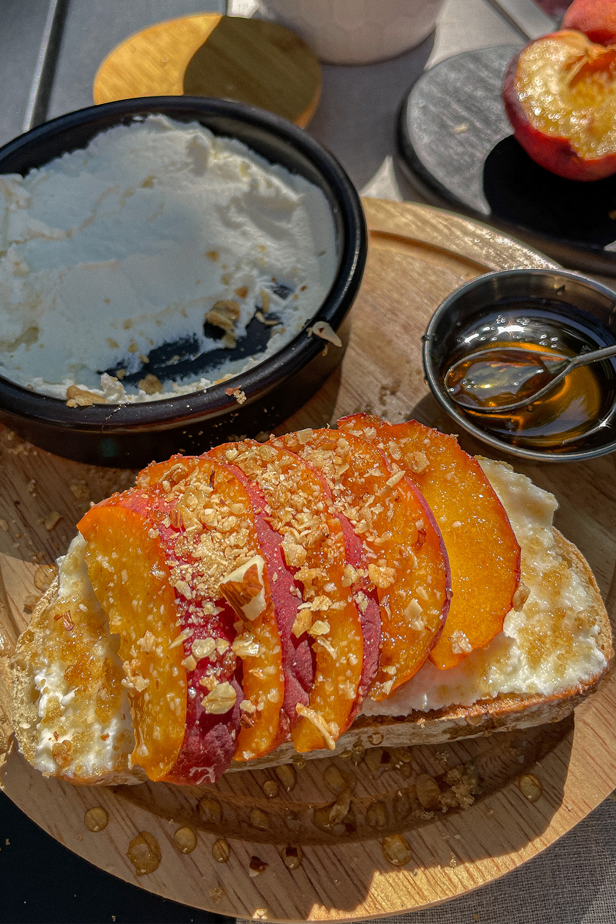 Beautiful slice of Peach Ricotta Toast on a wooden tray