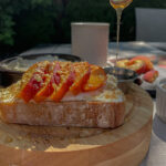 Pouring honey over Peach Ricotta Toast