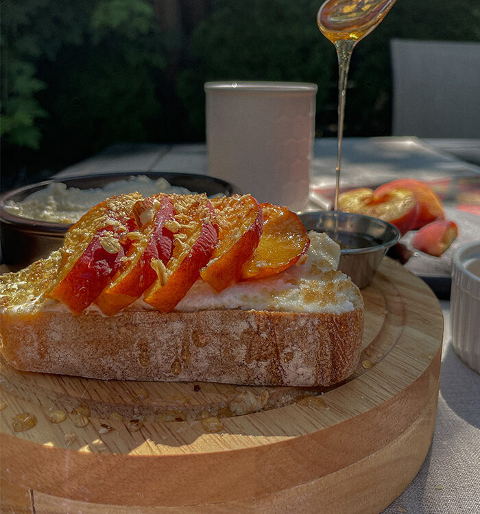 Pouring honey over Peach Ricotta Toast