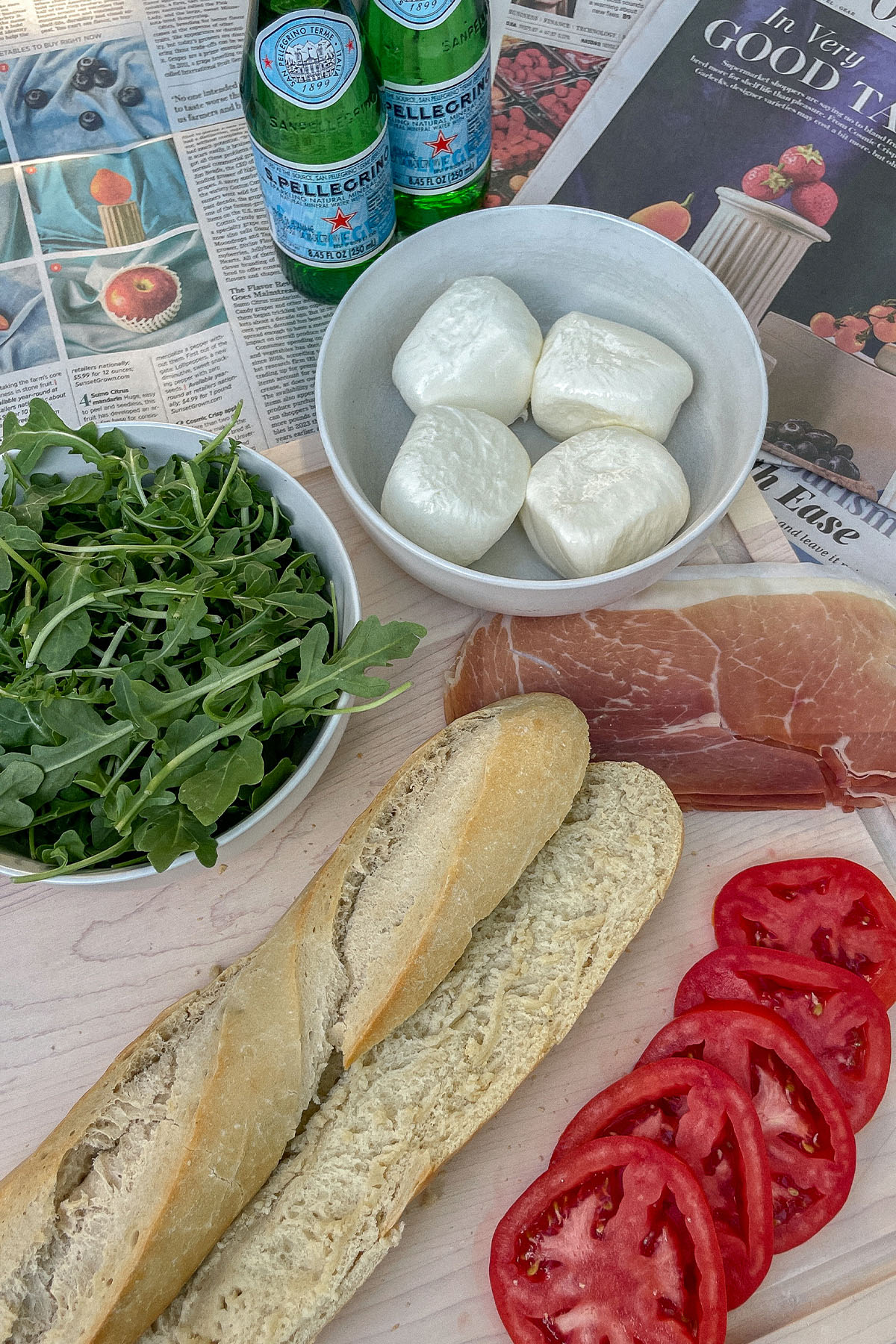 Prosciutto Burrata Baguette Sandwich ingredients on a wooden cutting board