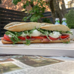 Prosciutto Burrata Baguette Sandwich on a wooden cutting board