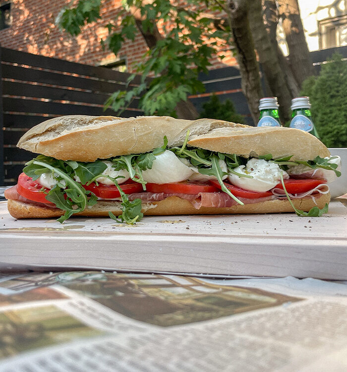 Prosciutto Burrata Baguette Sandwich on a wooden cutting board