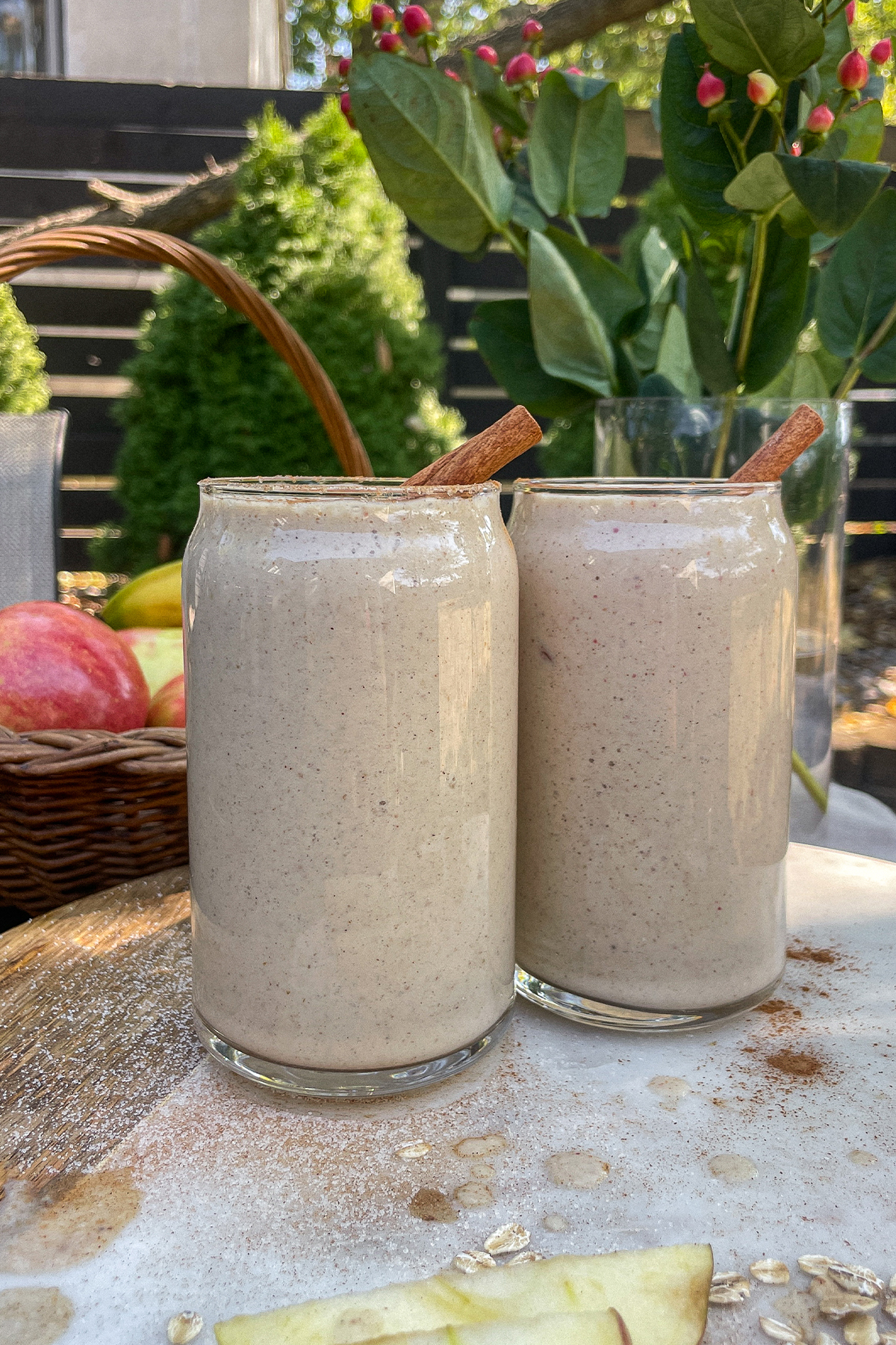 Maple Apple Crisp Smoothies served in clear glasses topped with a sprinkle of cinnamon and cinnamon sticks