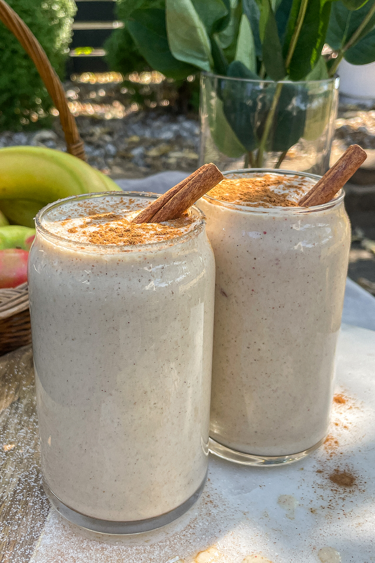 Maple Apple Crisp Smoothies served in clear glasses topped with a sprinkle of cinnamon and cinnamon sticks