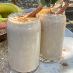 Maple Apple Crisp Smoothies served in clear glasses topped with a sprinkle of cinnamon and cinnamon sticks