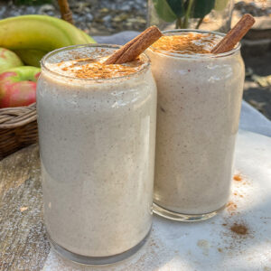 Maple Apple Crisp Smoothies served in clear glasses topped with a sprinkle of cinnamon and cinnamon sticks