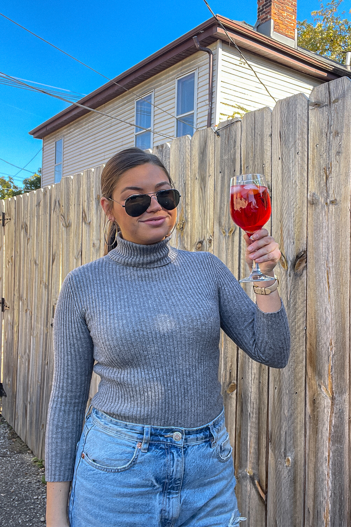 Tristen holding a Cranberry Aperol Spritz in a wine glass