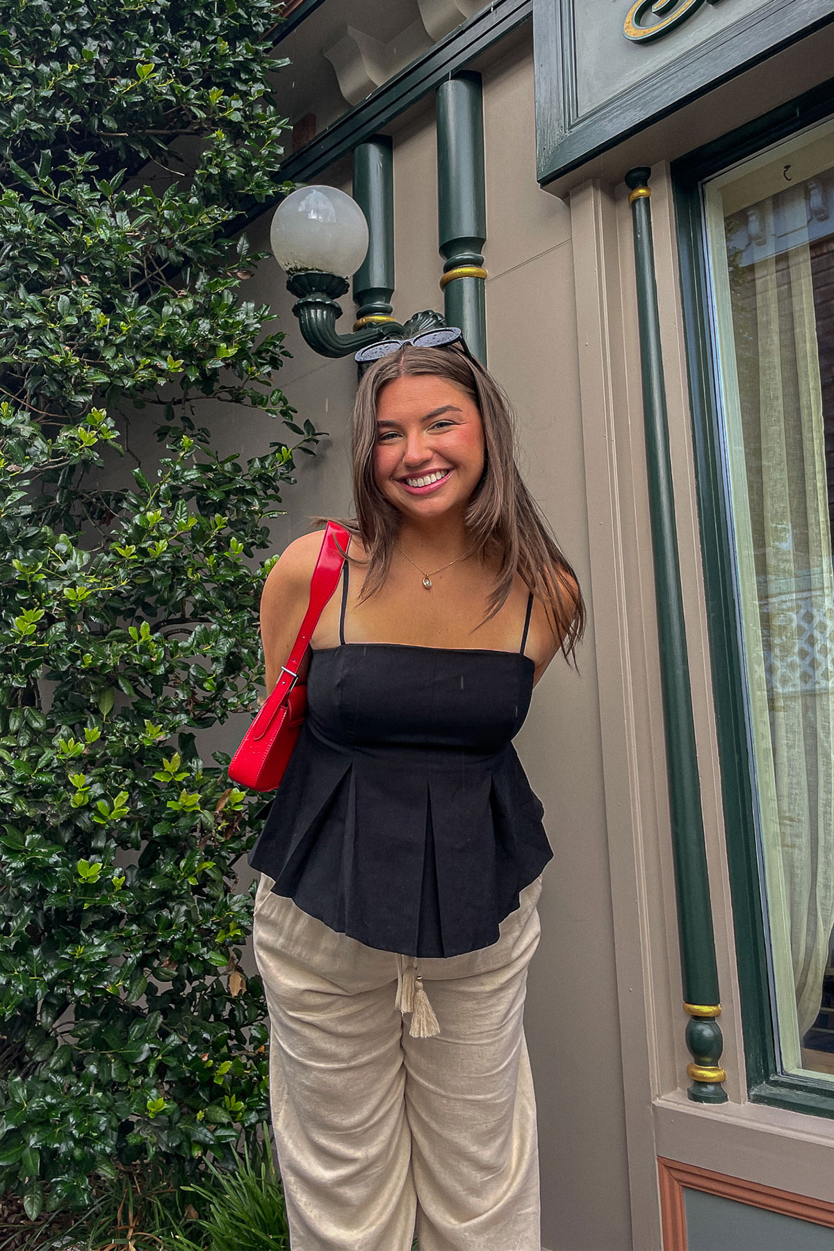 Tristen posing in front of a building covered in greenery