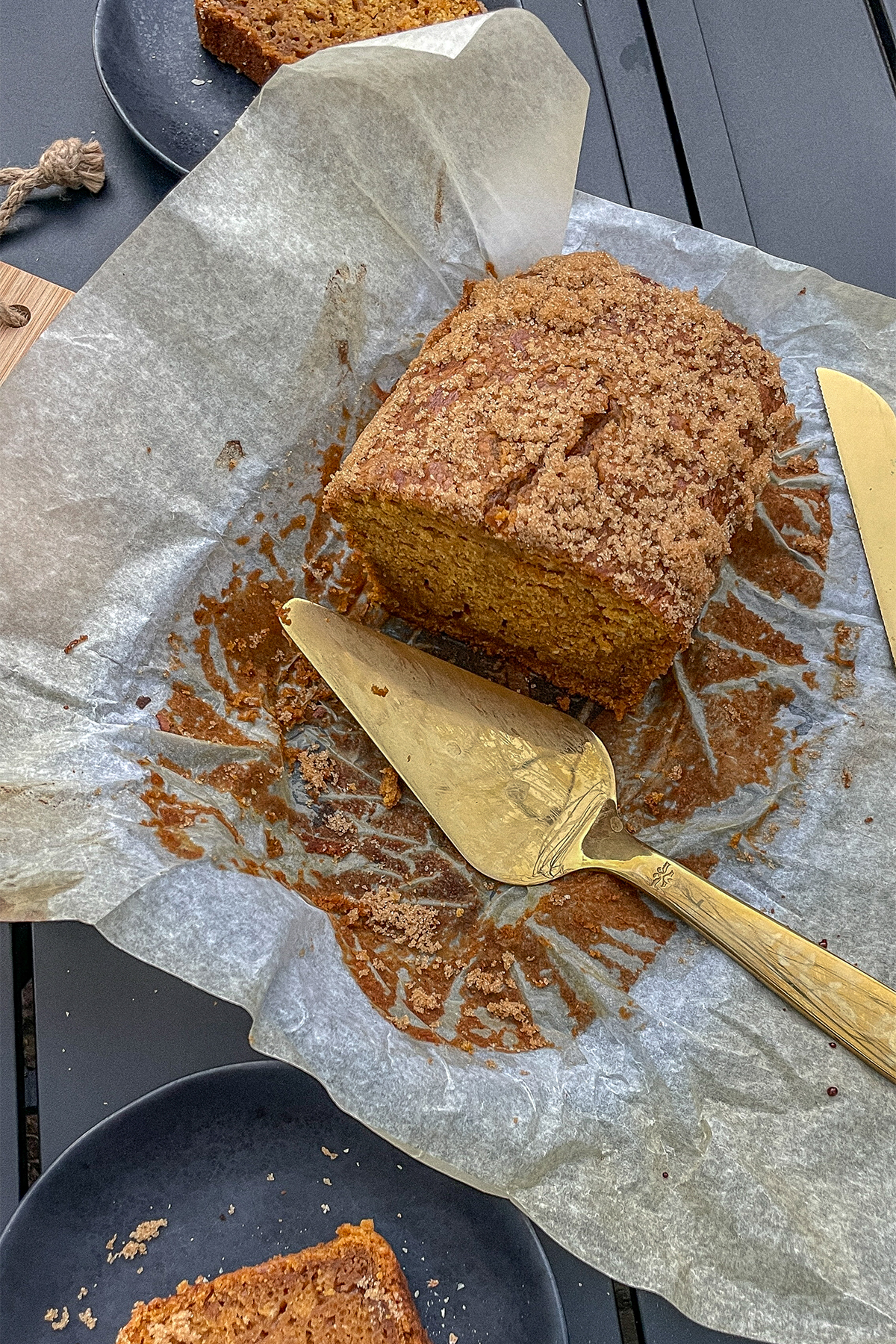 Pumpkin Spice Bourbon Bread served on parchment paper with pieces cut from it