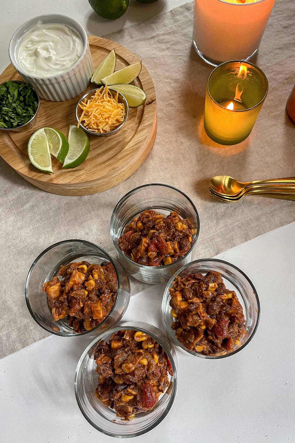 Southwest Sweet Potato Chili served in glass cups with a tray of toppings