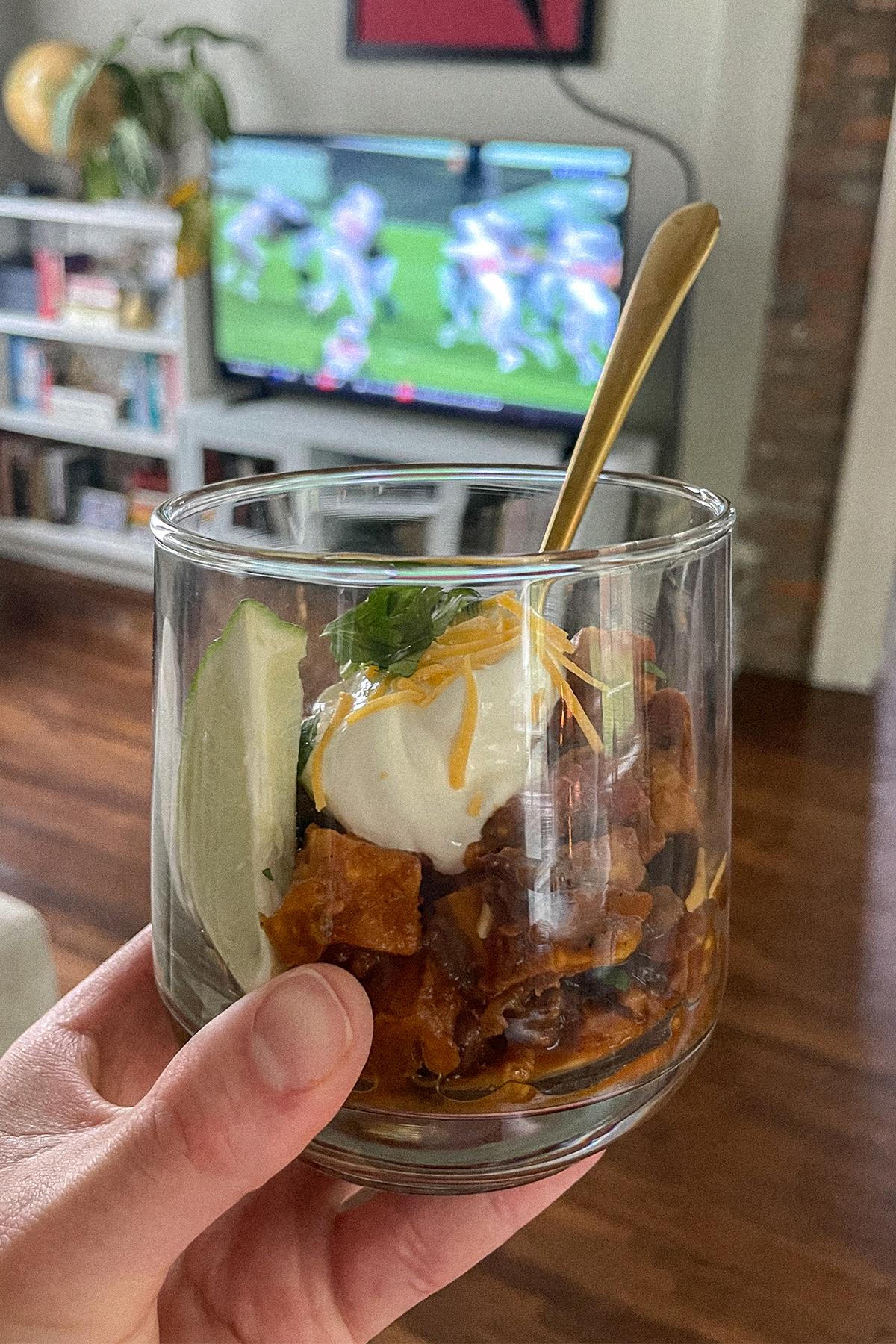 Southwest Sweet Potato Chili served in a glass cup with a lime wedge and cocktail spoon