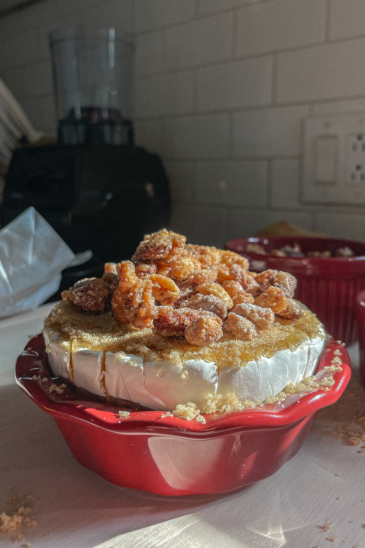 Brie topped with honey, brown sugar and candied nuts ready to put in the oven