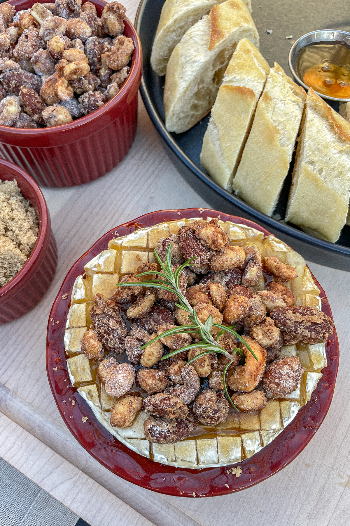 Brown Sugar Baked Brie With Candied Nuts in a small red pie dish