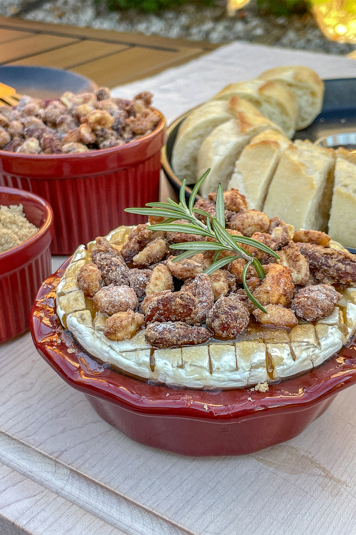 Brown Sugar Baked Brie With Candied Nuts in a small red pie dish