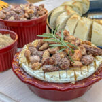 Brown Sugar Baked Brie With Candied Nuts in a small red pie dish