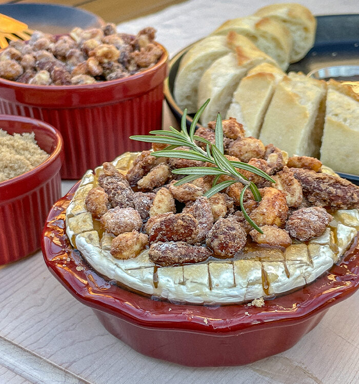 Brown Sugar Baked Brie With Candied Nuts in a small red pie dish