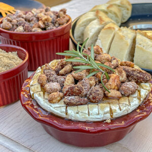 Brown Sugar Baked Brie With Candied Nuts in a small red pie dish