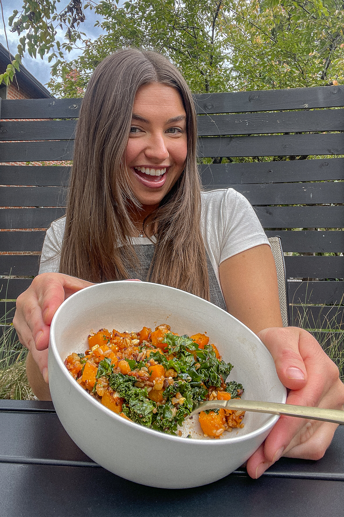 Tristen holding a bowl of Roasted Butternut Squash Quinoa Salad