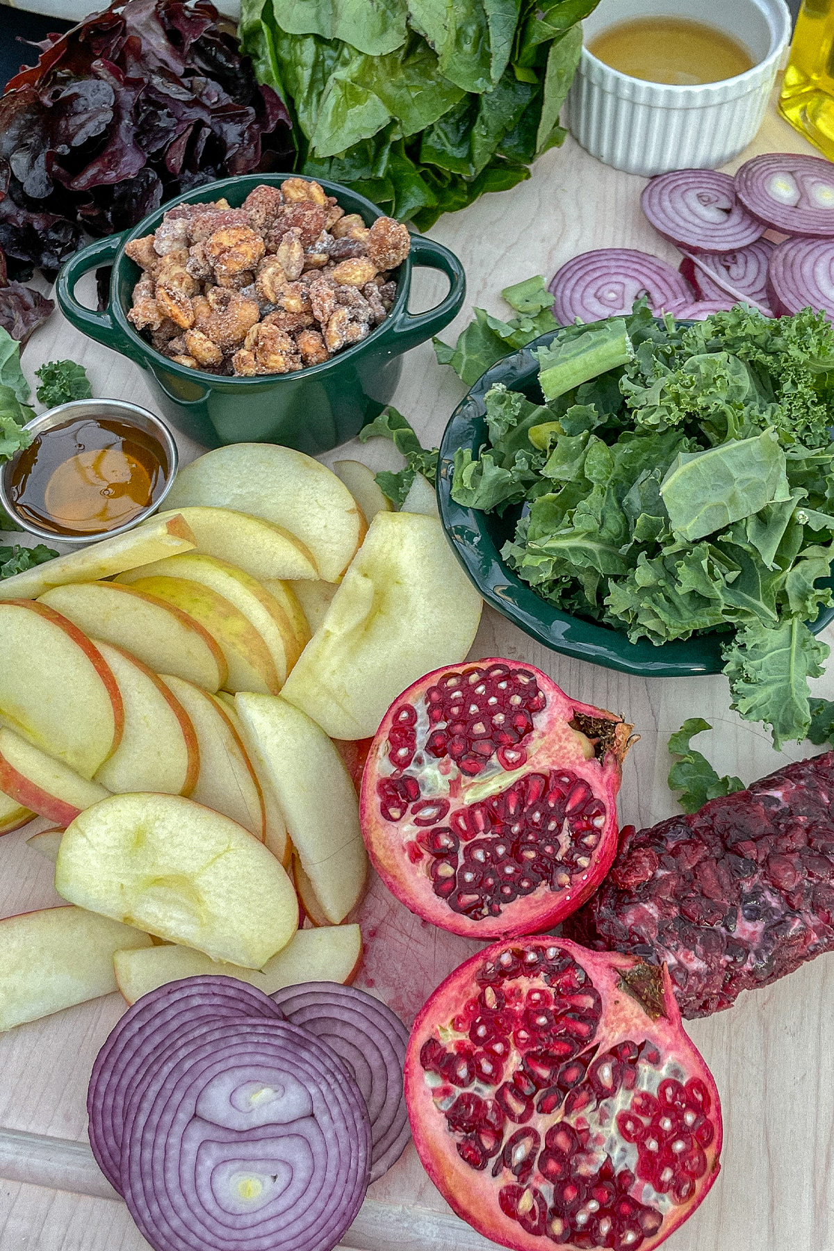 Kale Apple Salad With Cranberry Goat Cheese ingredients displayed on a cutting board