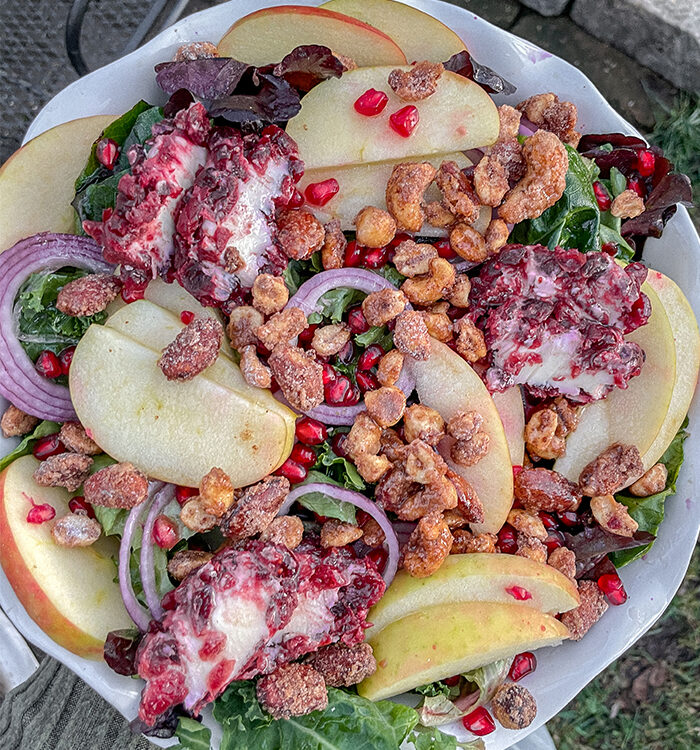 Kale Apple Salad With Cranberry Goat Cheese served in a white ruffle pie dish