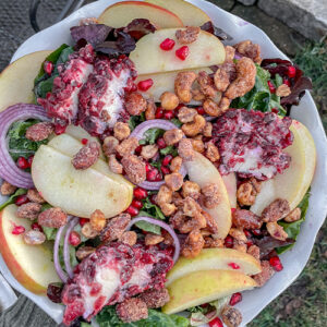 Kale Apple Salad With Cranberry Goat Cheese served in a white ruffle pie dish